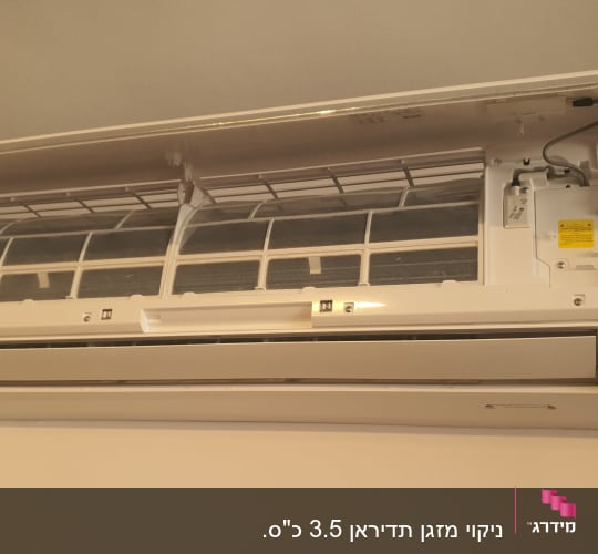 מזגן מותקן על קיר עם מכסה פתוח